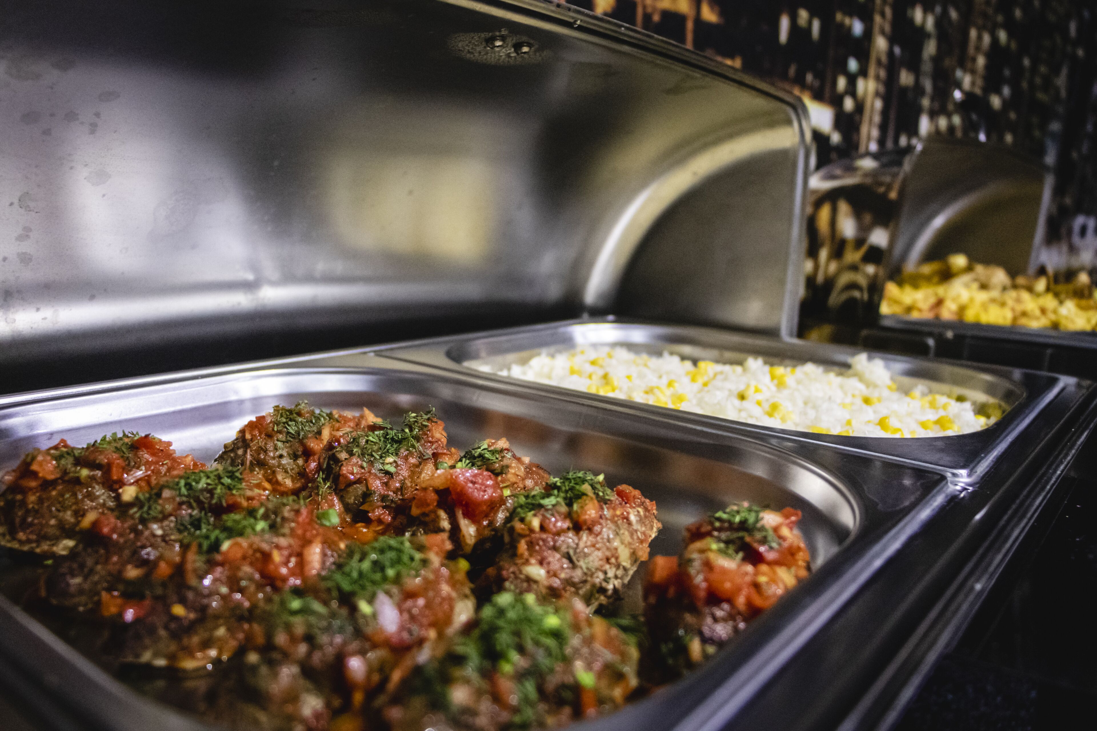 A buffet with various dishes including meatballs and rice.