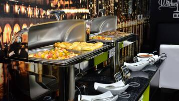 A buffet setup with various food items and utensils.