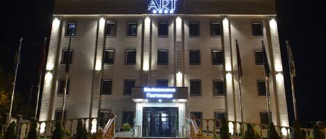 Un hôtel avec une enseigne indiquant « HOTEL ART » et « Международная Гостиница », ce qui signifie qu’il s’agit d’un hôtel.