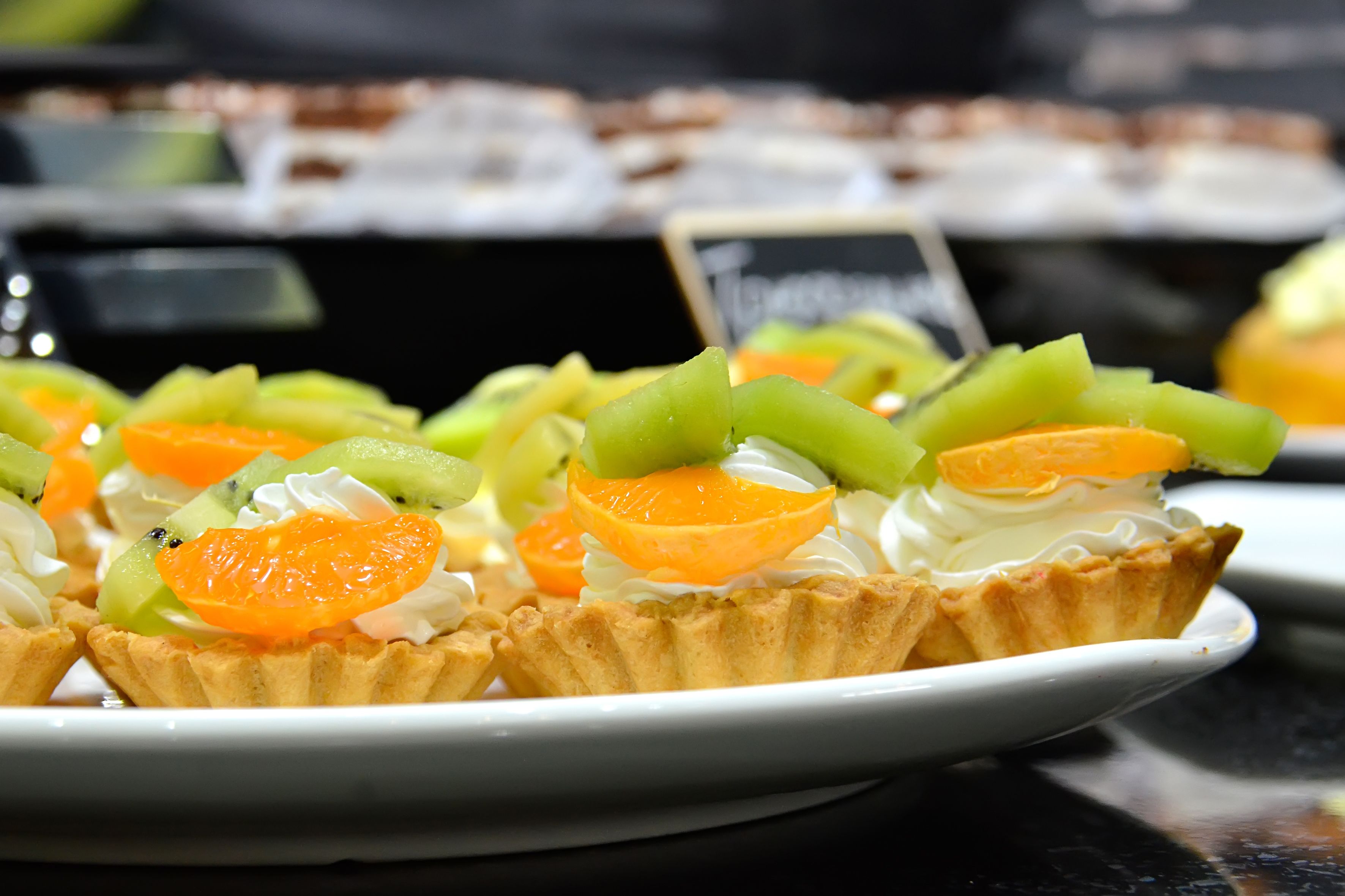 A dessert plate with fruit tarts and whipped cream.