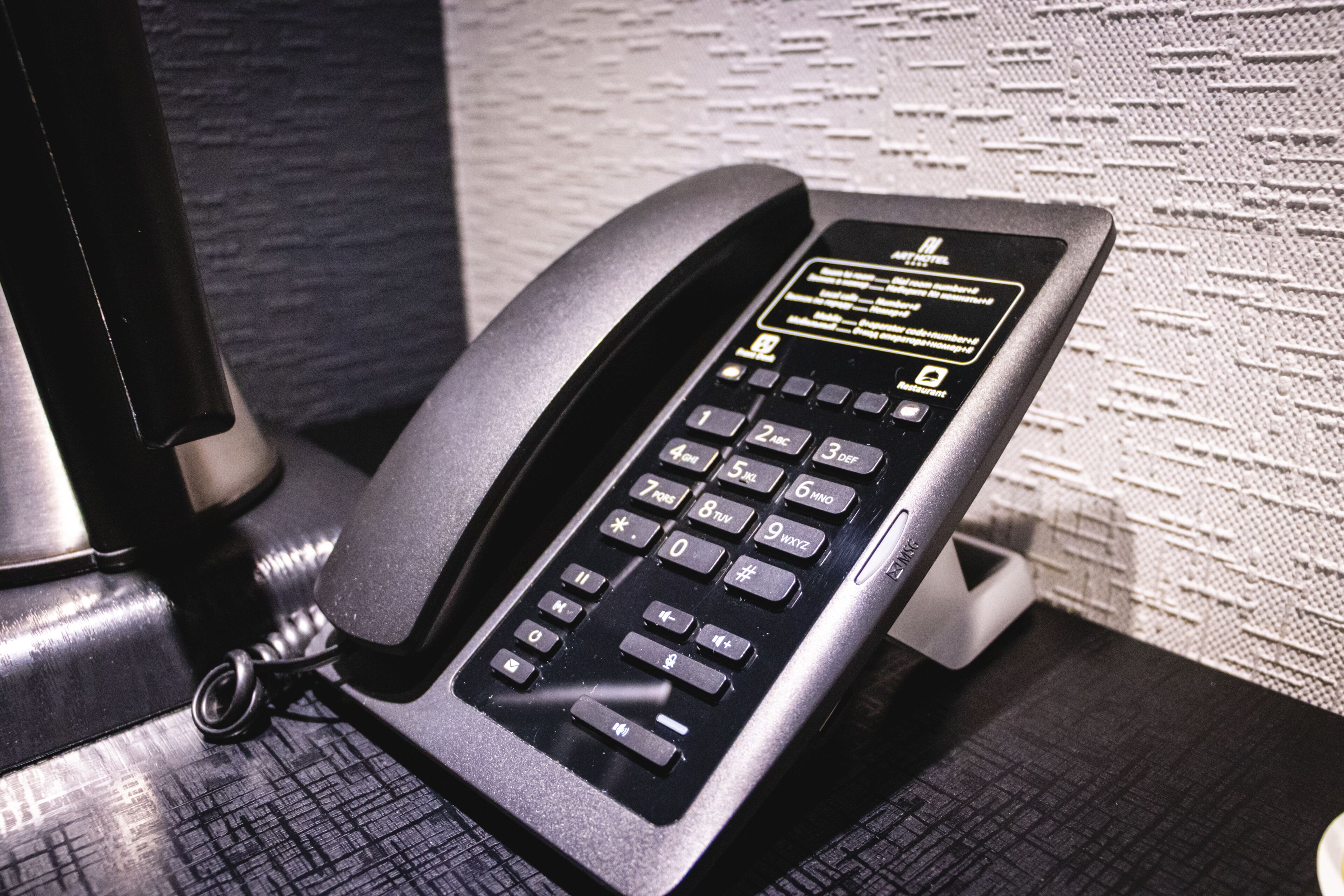 A black telephone on a textured surface.