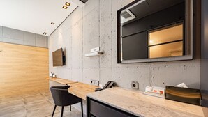 A modern kitchen with a marble countertop, a built-in oven, and a wooden dining area. - The HongC Hotel Gangneung (Gangneung)