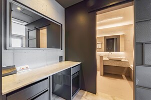 A modern bathroom with a large mirror, a sink, and a shower area.