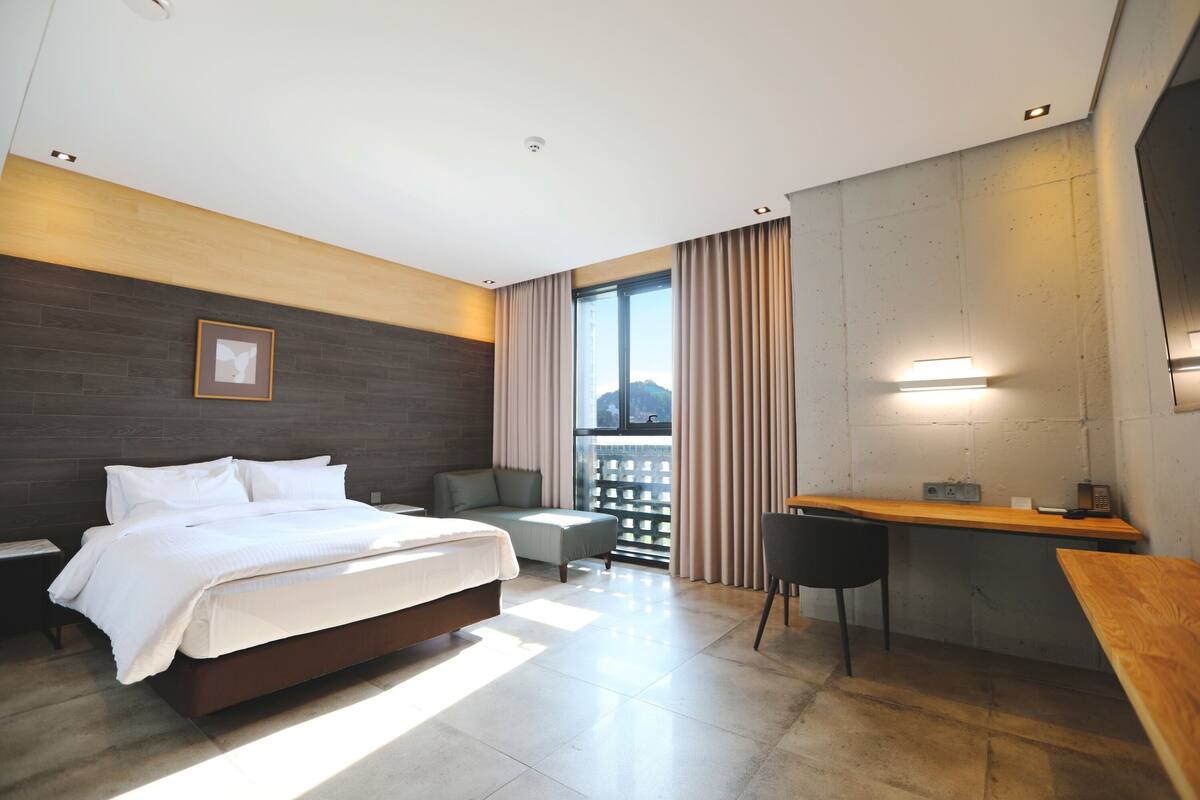 Une chambre d’hôtel moderne, dotée d’un grand lit, d’un bureau et d’un coin salon.