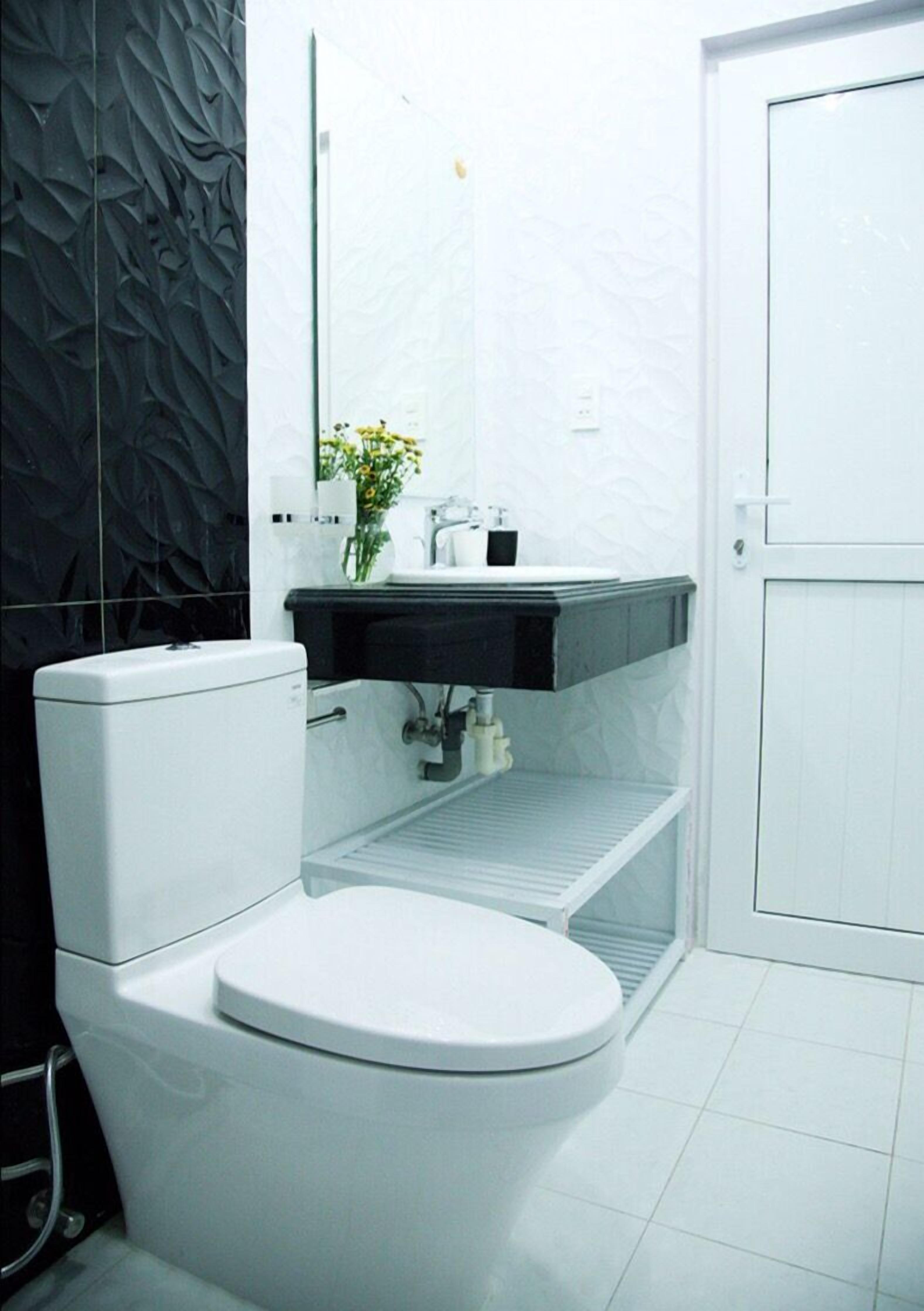 A modern bathroom with a toilet, a sink, and a mirror.