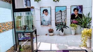 A hotel lobby with a fish tank, potted plants, and promotional posters. - HT Hotel Apartment (Ho Chi Minh City)