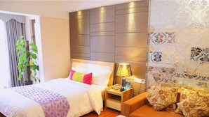 A hotel room with a bed, bedside table, lamp, and a sofa. - YUMI Apartment-Pujun Station Branch (Foshan)