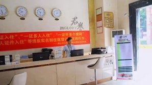 A reception desk with clocks, a red banner with text, and a signboard. - YUMI Apartment-Pujun Station Branch (Foshan)