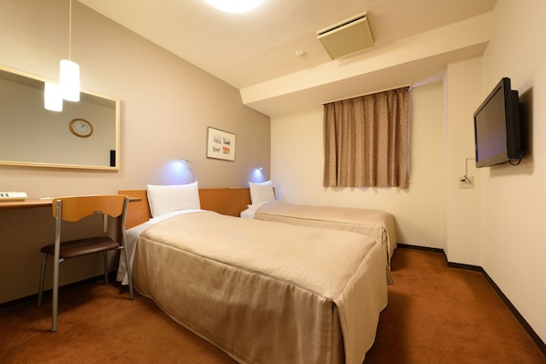 Une chambre d’hôtel avec deux lits, un bureau, une chaise, une horloge, un téléviseur et une fenêtre avec des rideaux.