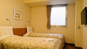 Habitación de hotel con dos camas, una ventana con cortinas, un televisor de pantalla plana montado en la pared y un cuadro enmarcado.
