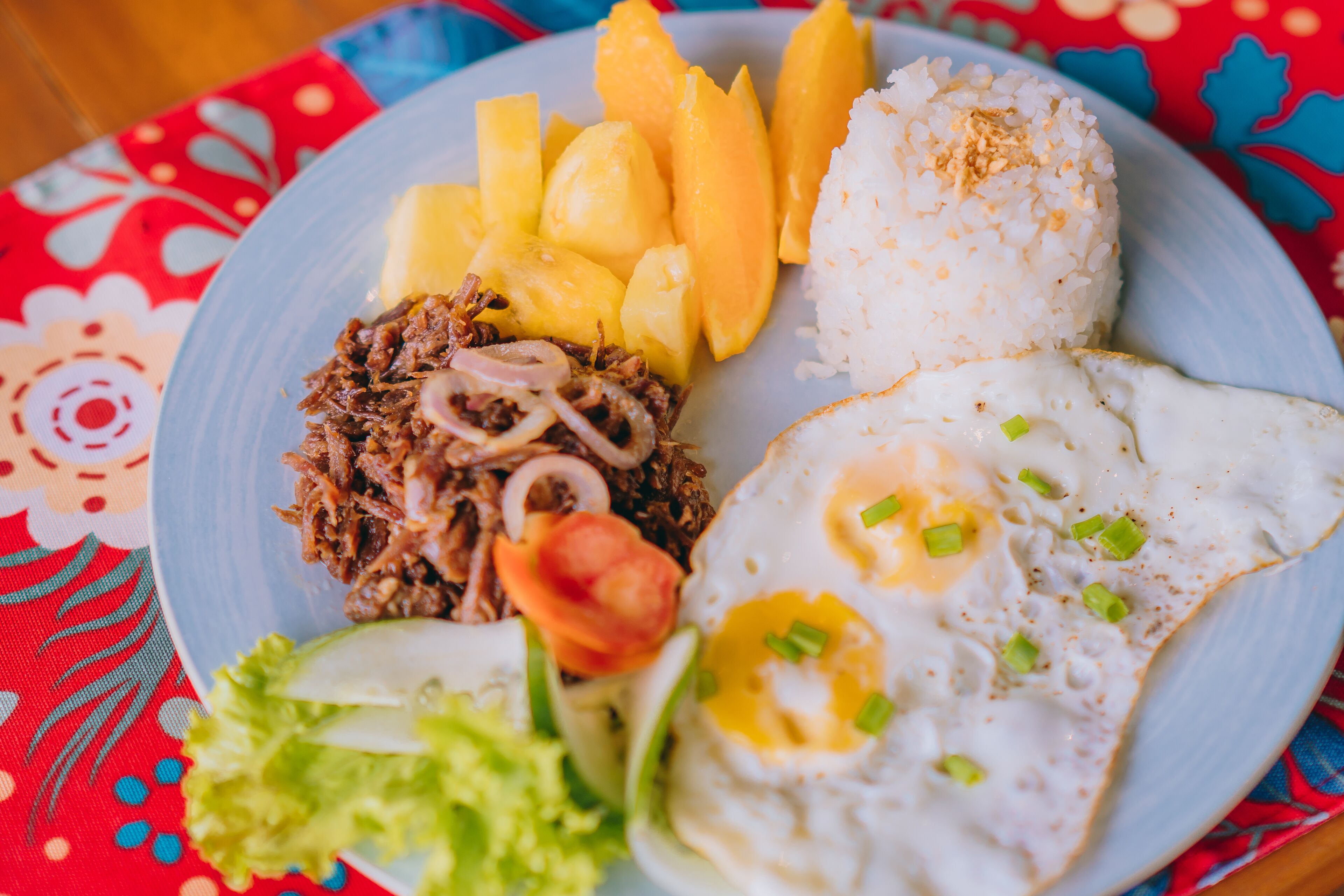 A plate of food with rice, fried egg, and meat.