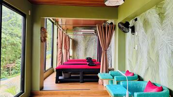 Relax in a stylish room with a large window offering a view of lush greenery, a comfortable bed, and a cozy seating area.