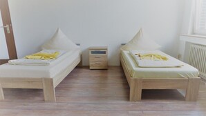 A room with two single beds, each with a pillow and a small bedside table. - Hotel-Restaurant Dümptener Hof (Muelheim an der Ruhr)