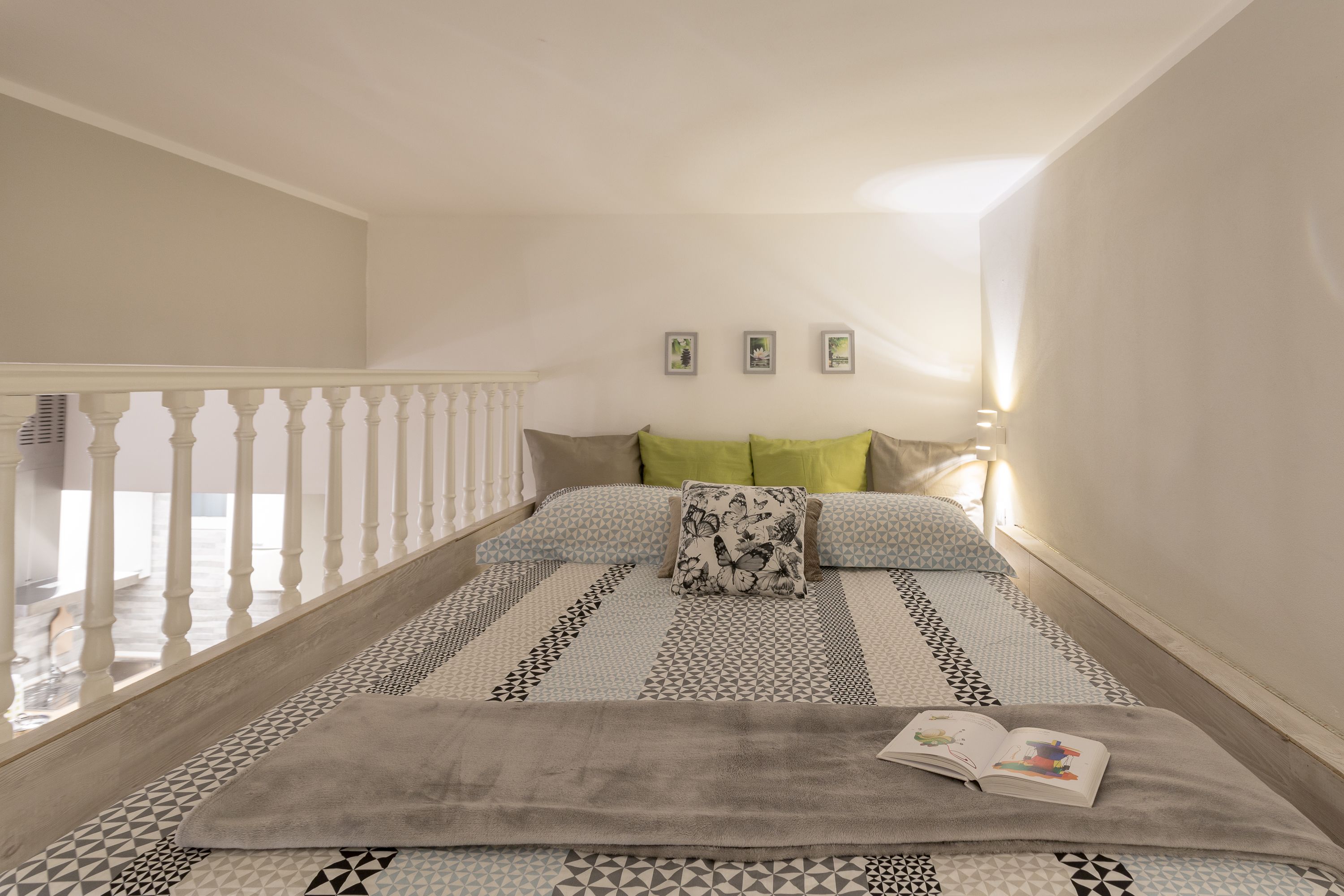 A bedroom with a bed, a window, and a staircase.