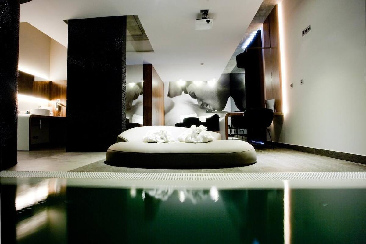 A modern bathroom with a large mirror, a sink, and a toilet.