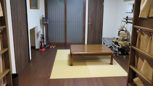 A room with a wooden floor, a tatami mat, a wooden table, and a wardrobe. - Azalea - Hostel (Osaka)