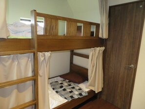 A bunk bed with a wooden frame, a white mattress, and a checkered blanket. There is a door to the right and a window above the bed. - Azalea - Hostel (Osaka)
