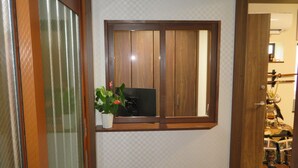 A room with a wooden door, a window with a checkered pattern, and a plant on the windowsill. - Azalea - Hostel (Osaka)