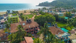Un pueblo costero con una playa, un hotel llamado 'LAR'S' y zonas verdes circundantes.
