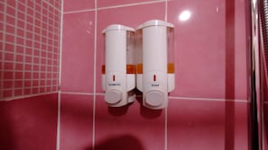 Two dispensers labeled 'SHAMPOO' and 'SOAP' mounted on a pink tiled wall. - SPN Place Ratchada (Bangkok)