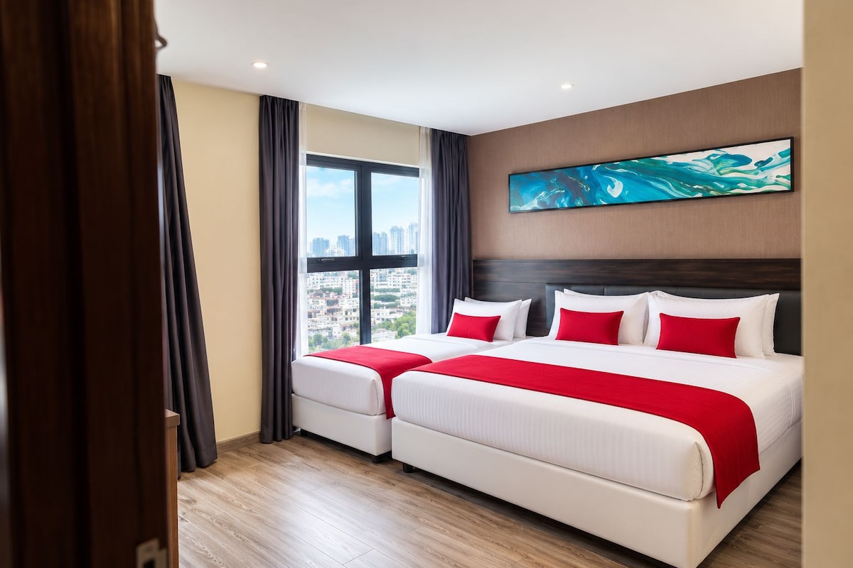 Een hotelkamer met twee bedden, een groot raam en uitzicht op de stad.