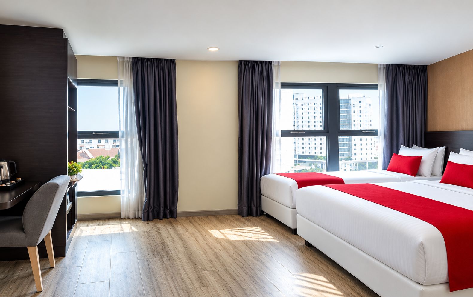 A hotel room with a bed, a desk, and a view of the city.