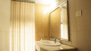 A bathroom with a sink, mirror, and shower curtain. - White Orchid (Cox's Bazar)