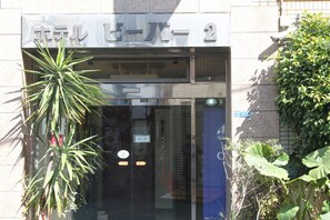 Une entrée d’immeuble avec une pancarte indiquant le numéro de la salle : 2.