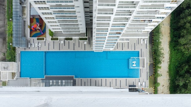 A rooftop swimming pool with a modern design, surrounded by high-rise buildings. - Duet HomeStay (Seri Kembangan)