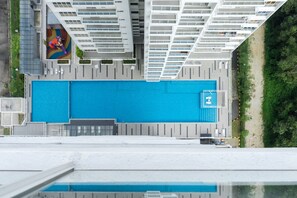 A rooftop swimming pool with a modern design, surrounded by high-rise buildings. - Duet HomeStay (Seri Kembangan)