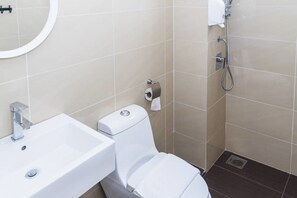 A bathroom with a white sink, toilet, and shower. - Duet HomeStay (Seri Kembangan)