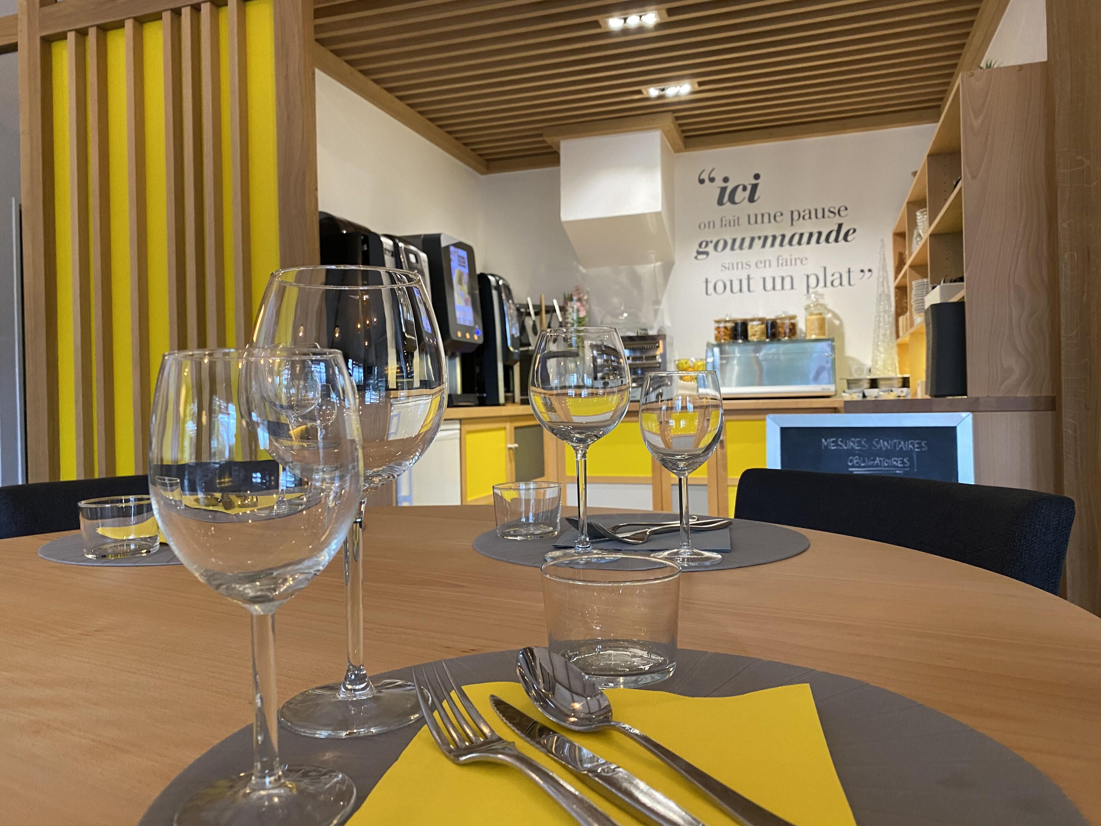 Un ambiente de restaurante con una mesa dispuesta para comer, que incluye copas de vino, cubiertos y una servilleta.