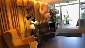 A hotel lobby with two armchairs, a lamp, and a potted plant. - Fasthôtel Biarritz Bidart Côte Basque - FH Collection (Bidart)