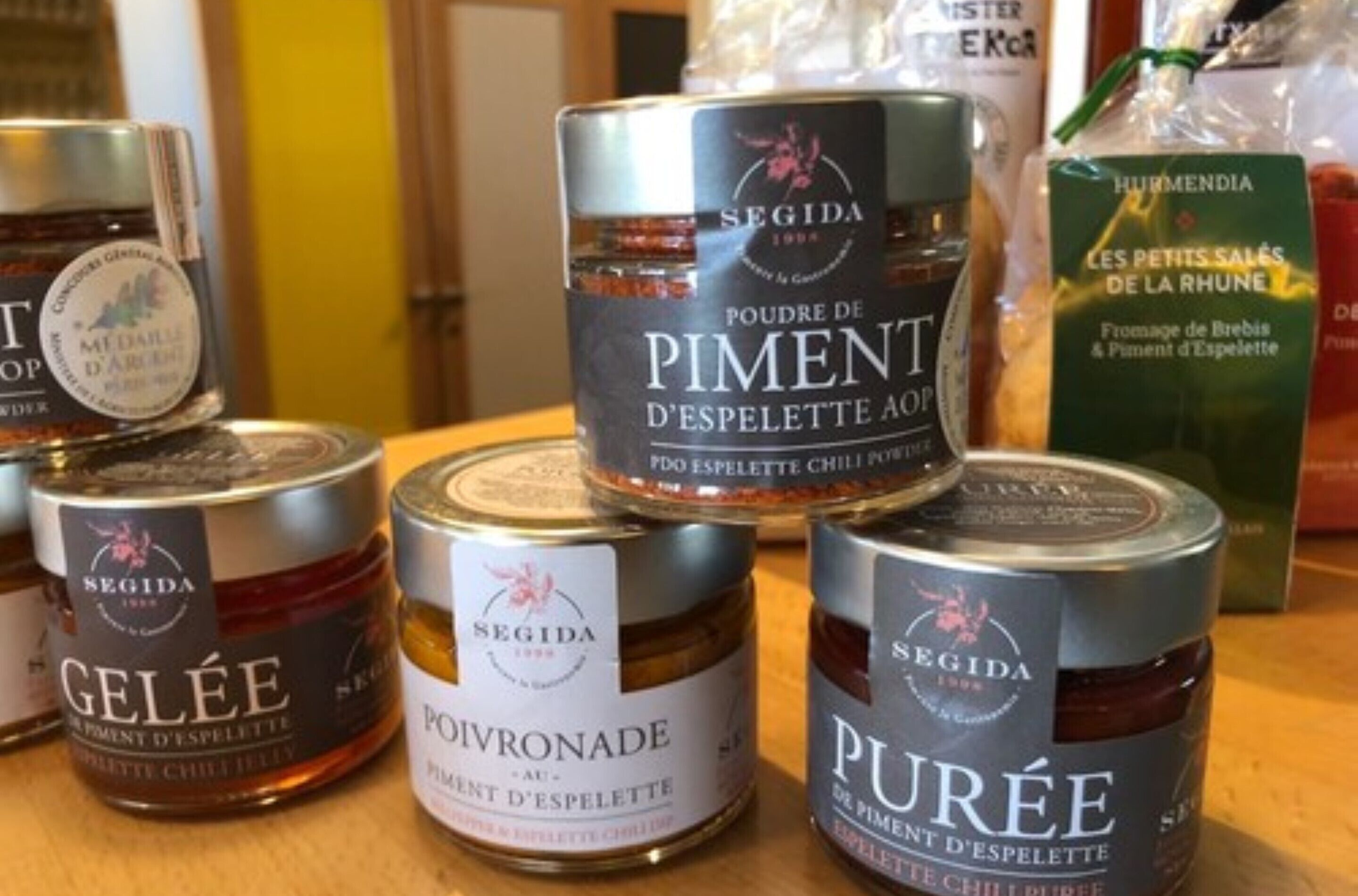 Verschiedene Gläser Gewürze und Saucen der Marke Segida, darunter Piment d'Espelette und Gelée.