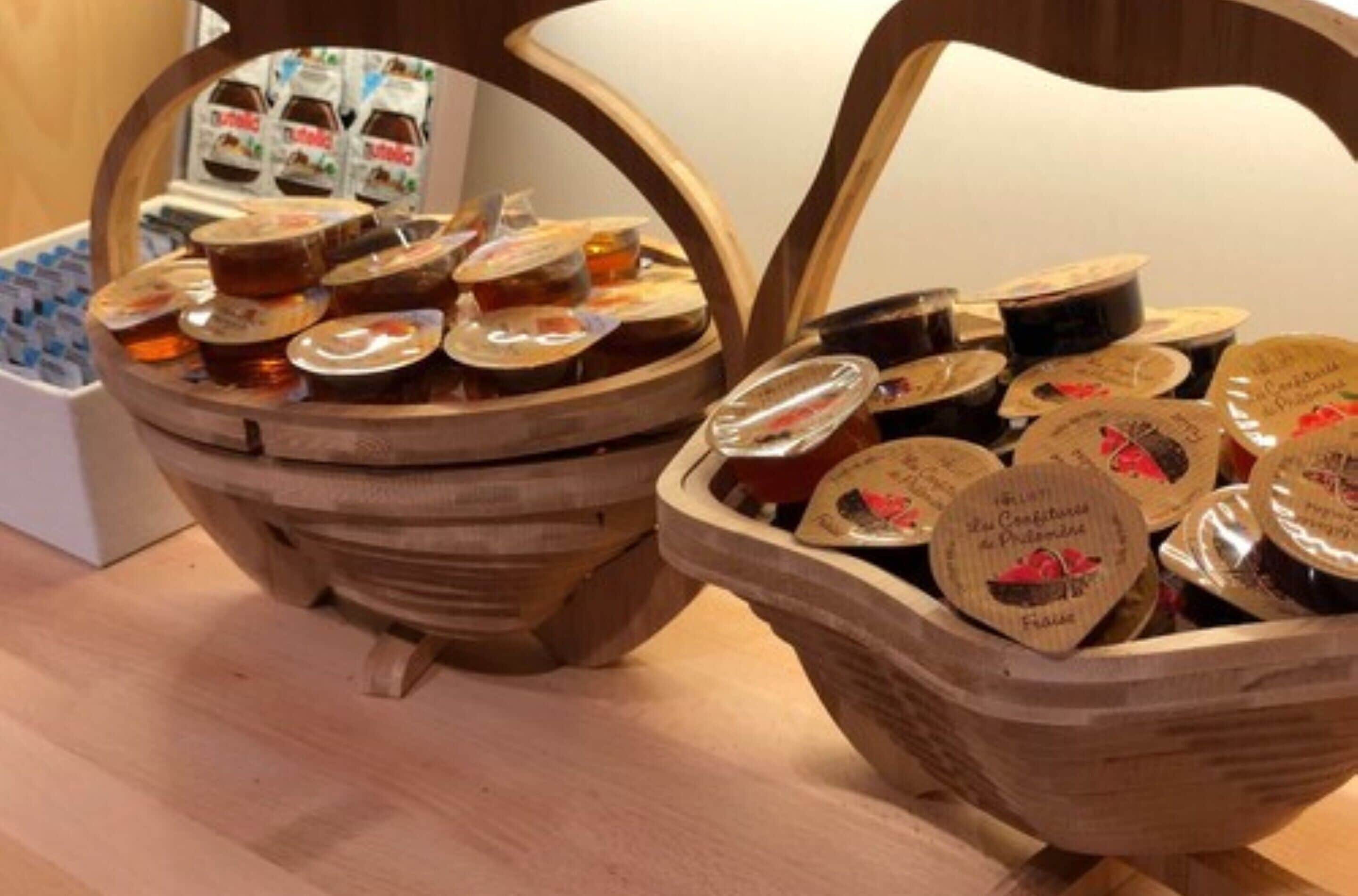 Two wooden baskets filled with jars of honey and honeycomb.