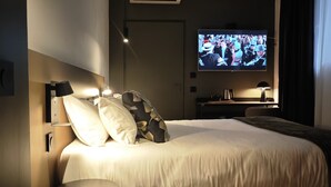 A modern hotel room with a large bed, a TV on the wall, and a small side table. - Fasthôtel Biarritz Bidart Côte Basque - FH Collection (Bidart)