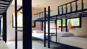 Habitación con literas, ventana, puerta y suelo de baldosas.