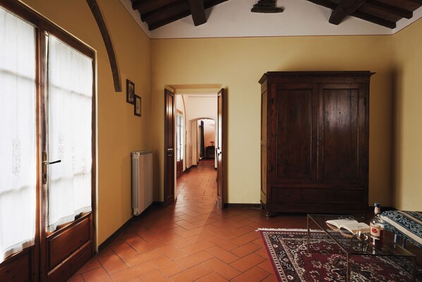 A hallway with a wooden cabinet, a radiator, and a rug. - Agriturismo Il Borgo (Cortona)