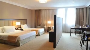 A hotel room with two beds, a desk, a chair, and a television. - Grand Inn Xijiao State Guest Hotel (Shanghai)
