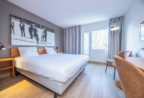 A modern hotel room with a large bed, a desk, and a window with curtains. - Fletcher Resort-Hotel Zutphen (Zutphen)