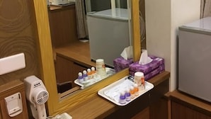 A hotel room with a large mirror, a hairdryer, a telephone, and a small trash bin. - Ri Yue Hu Pan Hotel (Yuchi)