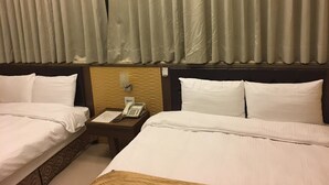 A hotel room with two beds, a nightstand with a phone, and a headboard with a light fixture. - Ri Yue Hu Pan Hotel (Yuchi)