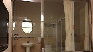 A bathroom with a sink, mirror, and glass shower enclosure. - Ri Yue Hu Pan Hotel (Yuchi)