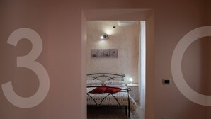 A bedroom with a bed, a nightstand, a lamp, and a wall-mounted air conditioner. - B&b Viatrento30 (Salerno)