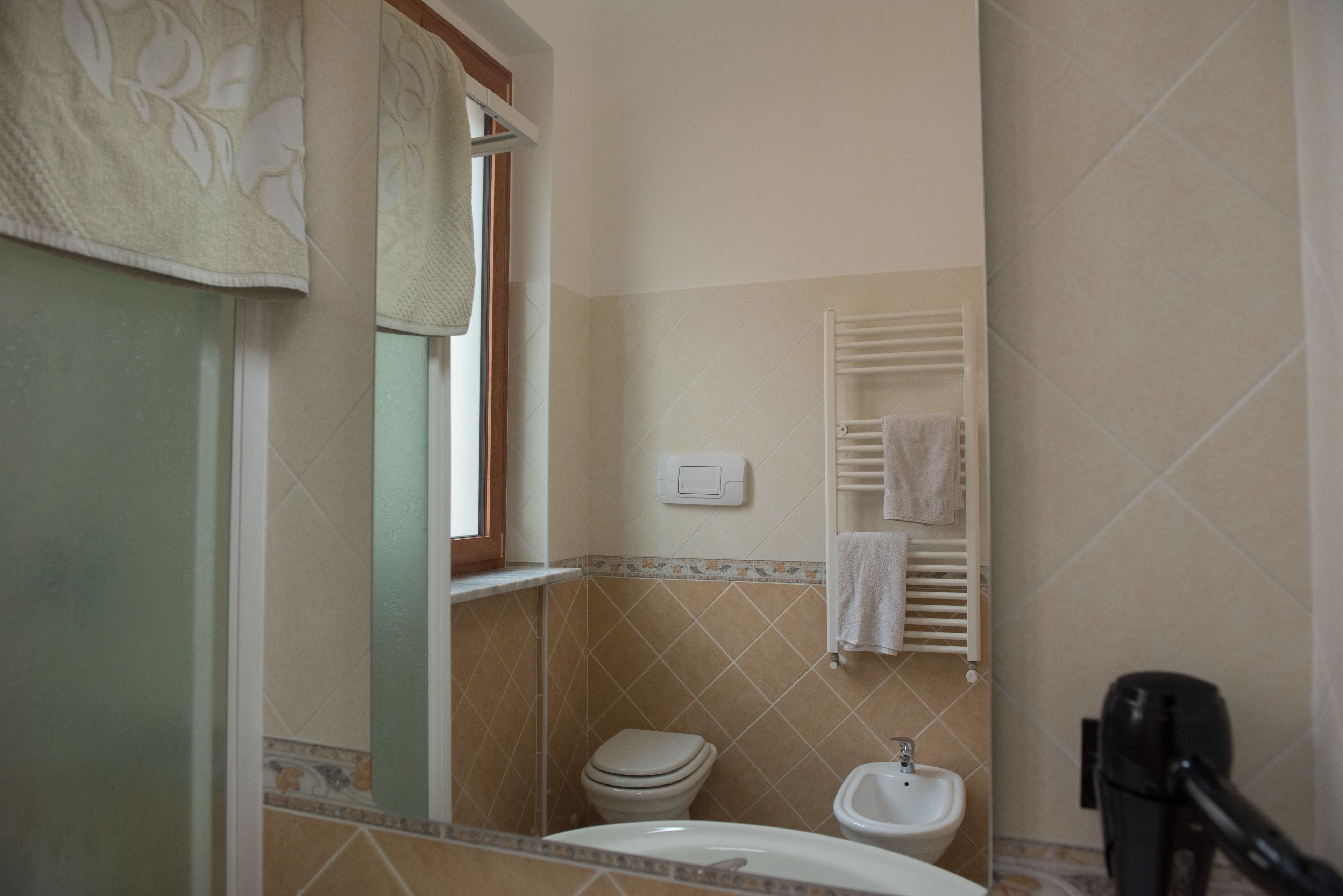 A bathroom with a toilet, sink, and towel rack.