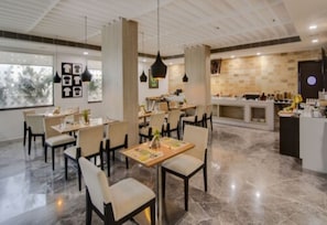 Un restaurante moderno con suelo de mármol, iluminación colgante y una isla central.
