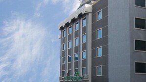 A modern hotel building with a curved facade and multiple windows. - Lemon Tree Hotel Banjara Hills (Hyderabad)