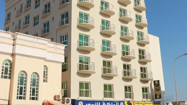 A multi-story hotel with balconies and a ground-level shop. - Al Nile Hotel (Salalah)