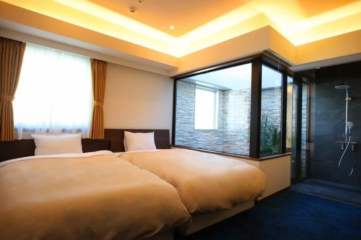 A hotel room with a large bed, a shower, and a view of the water.