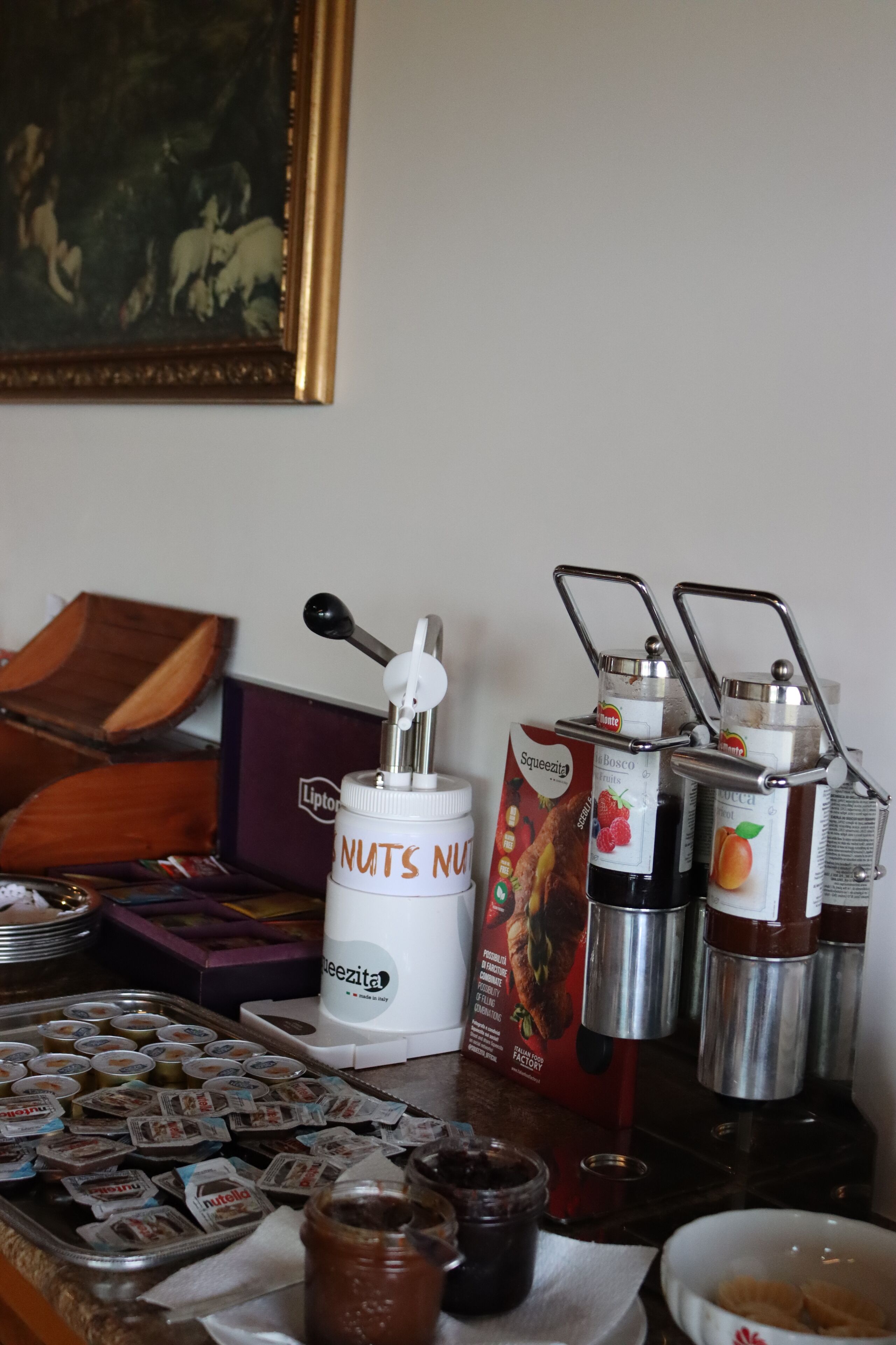 A table with a Nutella dispenser, a box of Nutella, and a coffee grinder.